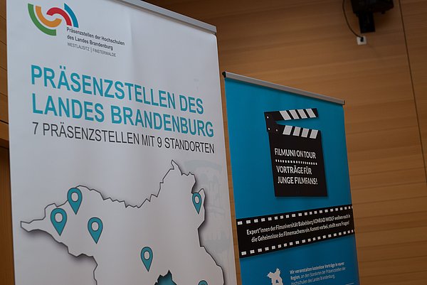 Werbe Roll-Ups der Präsenzstelle Westlausitz Finsterwalde und der Kinderfilmuni der Filmuni Babelsberg nebeneinander. 