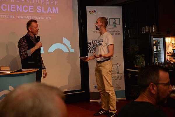 Teilnehmer der Brandenburger Science Slam 2022 auf der Bühne im Gespräch mit dem Moderator